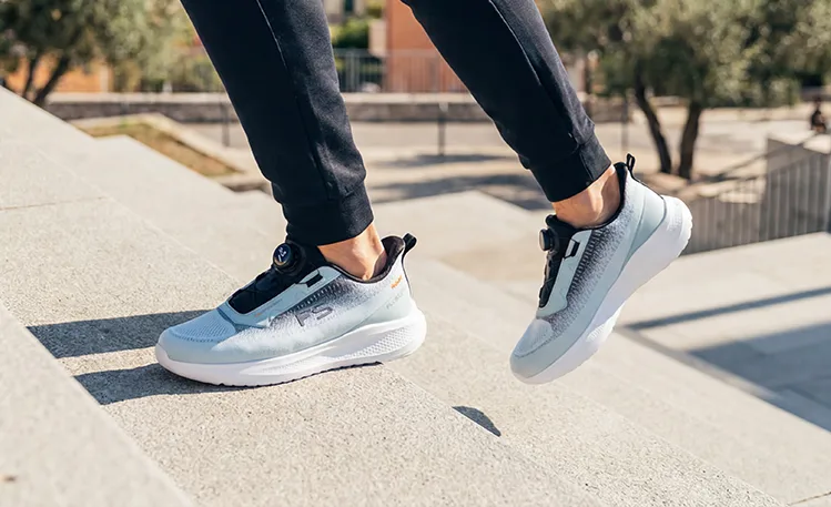 Mann zieht Fusion Schuhe in mediterraner Umgebung an