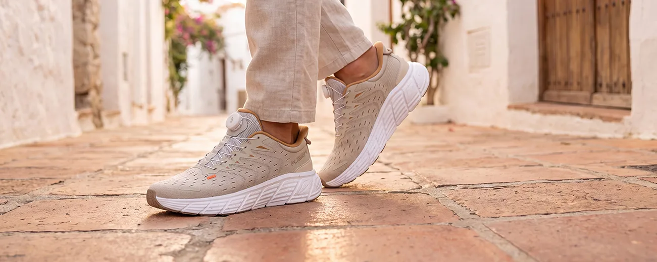 Frau trägt weiße Fusion Sportschuhe beim Spaziergang am Wasser