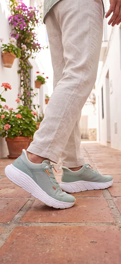 Mann trägt weiße Fusion Schuhe beim Gehen im Sommer